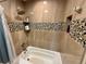 Updated bathroom features stone-look tiling on the walls, shower caddy, and in-wall shelving niche at 1063 Clarke Ct, Castle Rock, CO 80109