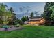 The expansive backyard features a lovely garden and patio area with string lights at 9678 E Powers Dr, Greenwood Village, CO 80111
