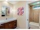 Bright bathroom featuring a modern vanity with a marble countertop and a tiled shower with glass door at 9678 E Powers Dr, Greenwood Village, CO 80111