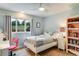 Cozy bedroom features a comfortable bed, natural light, and a built-in bookcase at 9678 E Powers Dr, Greenwood Village, CO 80111