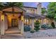 Inviting front entrance with a modern door, stone pillars, stylish lighting, and meticulously arranged rock landscaping at 9678 E Powers Dr, Greenwood Village, CO 80111