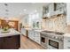 A spacious kitchen with white cabinetry, stainless steel appliances, and a view into the dining room at 9678 E Powers Dr, Greenwood Village, CO 80111