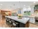 Spacious kitchen with a large island, bar seating, modern lighting, and a seamless connection to the dining area at 9678 E Powers Dr, Greenwood Village, CO 80111