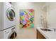 Efficient laundry room with stackable washer/dryer, marble countertop, sink, and shelving for organization at 9678 E Powers Dr, Greenwood Village, CO 80111