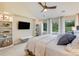 Serene main bedroom boasts vaulted ceiling, built-in shelving, and large windows overlooking lush greenery at 9678 E Powers Dr, Greenwood Village, CO 80111