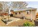 Back exterior of house with deck and small yard with tree mulch and an AC unit at 1171 Quebec St, Denver, CO 80220