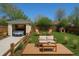 This backyard offers a wooden deck with outdoor seating, lush lawn and a detached garage at 1171 Quebec St, Denver, CO 80220