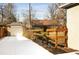 View of a backyard with a fence and detached garage with a long, white driveway at 1171 Quebec St, Denver, CO 80220