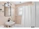 Bathroom featuring modern light fixture above the vanity, next to the shower and tub at 1171 Quebec St, Denver, CO 80220