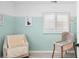 bedroom features mint and white painted walls, a chair, and a crib at 1171 Quebec St, Denver, CO 80220