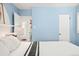 Cozy bedroom with light blue walls, white trim, and a view of the en-suite bathroom at 1171 Quebec St, Denver, CO 80220