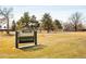 Close view of the Denison Park sign, playground, and expansive green spaces with mature trees at 1171 Quebec St, Denver, CO 80220