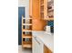 Bright kitchen featuring light wood cabinetry, pull-out shelves, dishwasher, and modern countertop at 1171 Quebec St, Denver, CO 80220