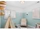 bedroom featuring light walls, window shutters, and a comfy chair at 1171 Quebec St, Denver, CO 80220