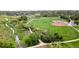 Aerial view featuring a vibrant green baseball field and a winding creek through a residential area at 2108 S Idalia St, Aurora, CO 80013