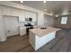 Well-lit kitchen with stainless steel appliances, white cabinets, and a large island with a sink at 6638 N Nepal Ct, Aurora, CO 80019