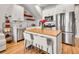 Updated kitchen with stainless steel appliances, butcher block island, and open shelving at 1303 Jersey St, Denver, CO 80220