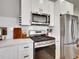 Renovated kitchen with modern stainless steel appliances and classic white cabinetry at 1303 Jersey St, Denver, CO 80220