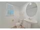 Half bathroom with a pedestal sink and round mirror at 18168 E Caley Cir, Aurora, CO 80016