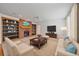 Cozy living room with a brick fireplace, built-in shelves, and comfortable seating, for relaxation at 18168 E Caley Cir, Aurora, CO 80016