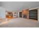 Open-concept living room features a brick fireplace and built-in bookshelves at 18168 E Caley Cir, Aurora, CO 80016