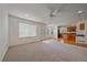 Bright living room with ceiling fan, neutral carpet, and views into kitchen at 18168 E Caley Cir, Aurora, CO 80016