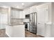 Modern kitchen boasts white cabinets, stainless steel appliances, and a granite-topped island with an open layout at 847 E 98Th Ave # 1806, Thornton, CO 80229