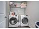 Efficient laundry room with side-by-side washer and dryer, and overhead storage at 952 Morning Glory Rd, Brighton, CO 80640