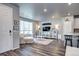 Bright living room with laminate flooring, large windows, and stylish white furniture at 952 Morning Glory Rd, Brighton, CO 80640