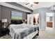 Cozy main bedroom featuring a decorative painting, a ceiling fan, and an ensuite bathroom at 12764 Ironstone Way # 103, Parker, CO 80134