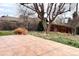 Paver patio in the back yard with mature trees, landscaping and wood fence at 1606 S Welch Cir, Lakewood, CO 80228
