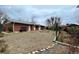 Expansive backyard with a large tree, brick house, and patio at 1606 S Welch Cir, Lakewood, CO 80228