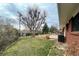 Grassy backyard featuring a large tree and a tiled patio at 1606 S Welch Cir, Lakewood, CO 80228