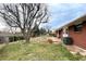 Secluded backyard with a large tree, garden beds, and patio area at 1606 S Welch Cir, Lakewood, CO 80228