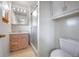 Clean bathroom with light wood vanity, shower, and toilet at 1606 S Welch Cir, Lakewood, CO 80228