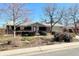 Charming ranch-style home with a well-maintained front yard and a pop of color from the front door at 1606 S Welch Cir, Lakewood, CO 80228