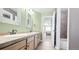 Well-lit bathroom with double sinks, tile flooring, and convenient access to primary bedroom at 23426 E Ottawa Dr, Aurora, CO 80016