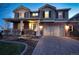 Two-story brick home featuring a covered porch, manicured lawn, and attached two-car garage at 23426 E Ottawa Dr, Aurora, CO 80016