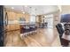 Open kitchen with wood floors, island with bar stools, stainless appliances, and sliding glass door to the outside patio at 23426 E Ottawa Dr, Aurora, CO 80016