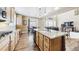 Spacious kitchen with a central island, wood cabinets, countertops, and an open layout with breakfast table overlooking living area at 23426 E Ottawa Dr, Aurora, CO 80016