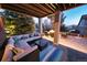 Covered patio boasts plush seating, an outdoor rug, and a fire pit for memorable evenings at 23426 E Ottawa Dr, Aurora, CO 80016
