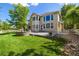 Beautiful backyard with a well-maintained lawn, fire pit, and mature shade trees at 3901 Stonegrass Pt, Broomfield, CO 80023