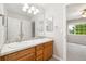 Bright bathroom featuring a double sink vanity and an open doorway to bedroom at 3901 Stonegrass Pt, Broomfield, CO 80023