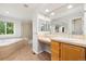 Bright bathroom featuring a soaking tub, glass enclosed shower, and a vanity with ample counter space at 3901 Stonegrass Pt, Broomfield, CO 80023
