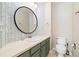 Stylish bathroom features patterned wallpaper and a round decorative mirror above the vanity at 3901 Stonegrass Pt, Broomfield, CO 80023