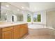 Well lit bathroom featuring a soaking tub, glass enclosed shower, and a vanity with counter space at 3901 Stonegrass Pt, Broomfield, CO 80023