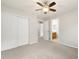 Bedroom with soft carpet, ceiling fan, closet doors and bathroom at 3901 Stonegrass Pt, Broomfield, CO 80023