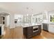 Kitchen with island and stainless appliances adjacent to living room with fireplace at 3901 Stonegrass Pt, Broomfield, CO 80023