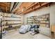 Large unfinished basement area with exposed ceiling and wooden shelving with a large mirror at 4620 W 108Th Pl, Westminster, CO 80031