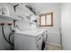 Bright laundry room with modern washer and dryer, storage shelves, and a window at 4620 W 108Th Pl, Westminster, CO 80031